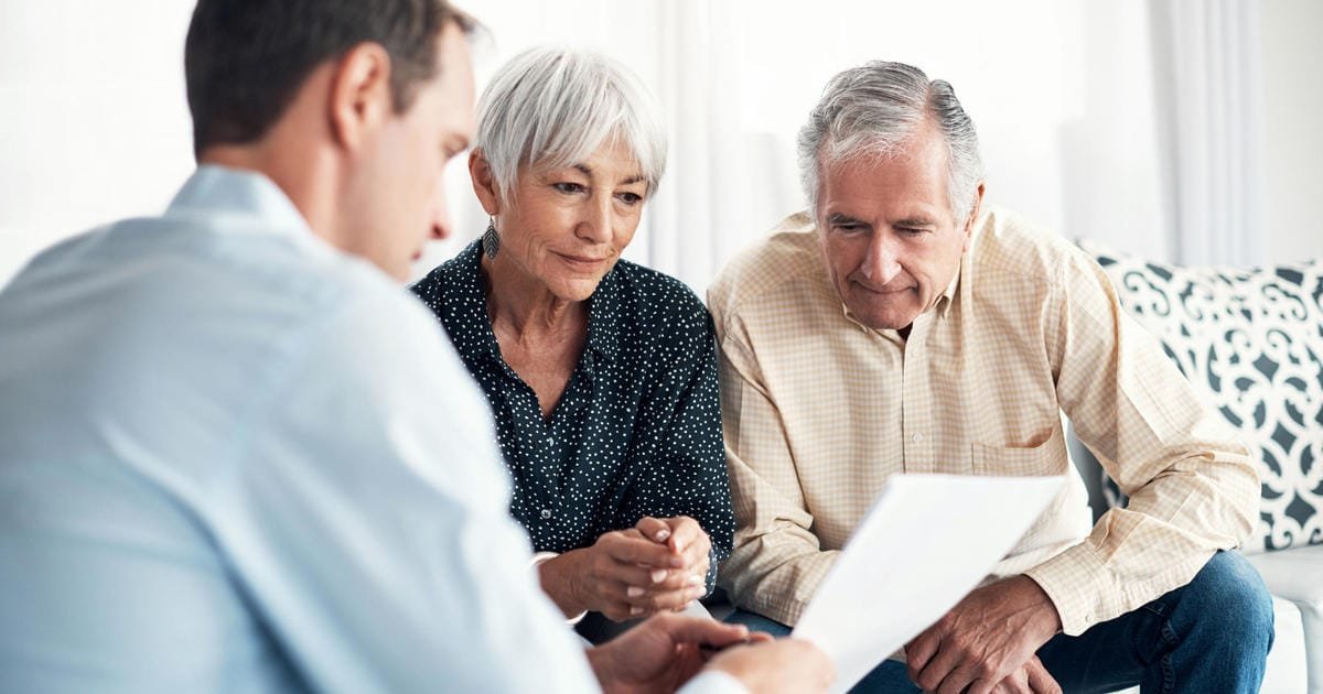 Life Settlement - an advisor showing a senior couple a contract. CHOOSING A LIFE SETTLEMENT BROKER