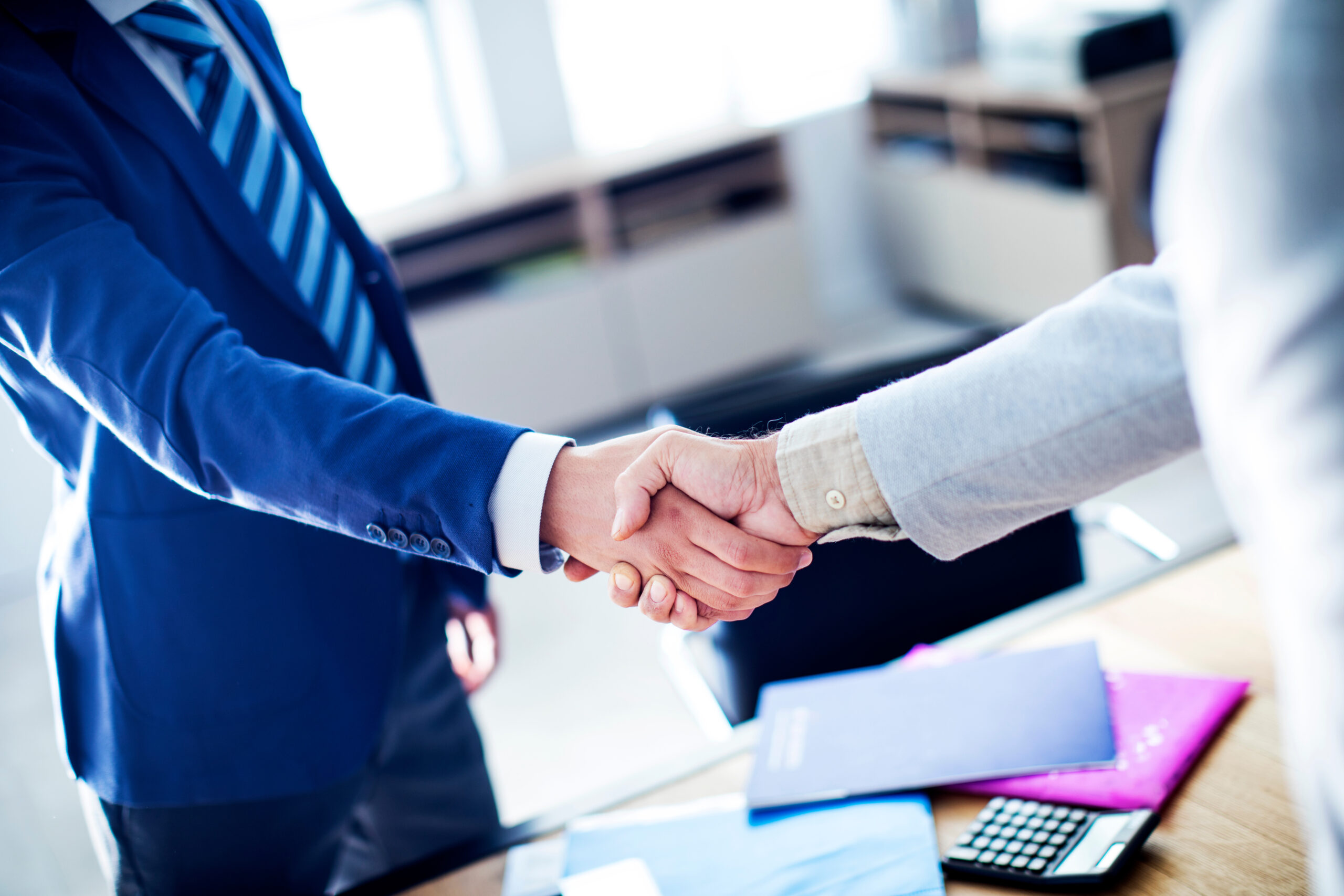 About Us: Life Settlement - Business handshake in the office