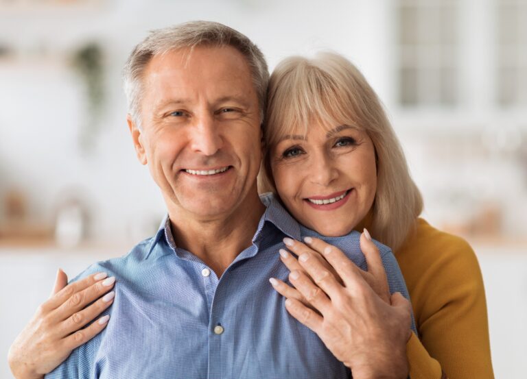 How Are Life Settlements Regulated? Senior Wife Embracing Husband Posing Together Standing In Kitchen.