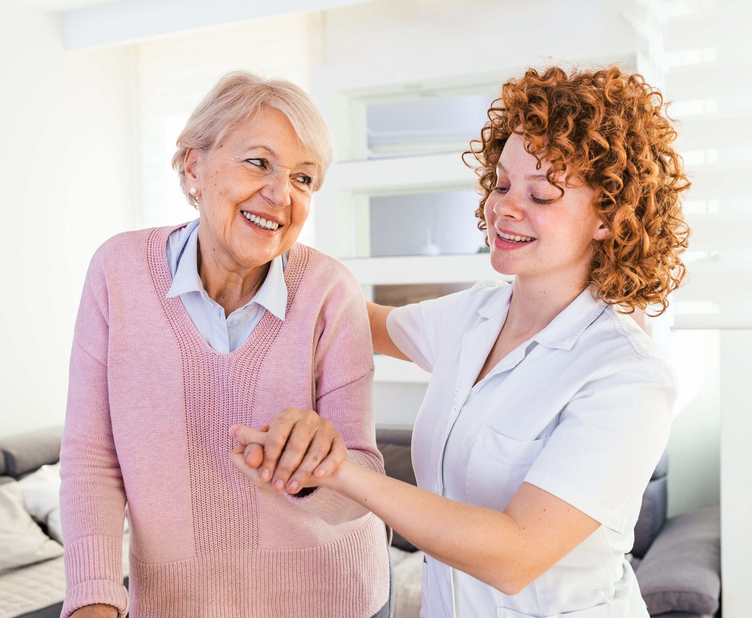 Accelerated Death Benefit - Life Settlement - Smiling nurse helping senior lady to walk around the nursing home.
