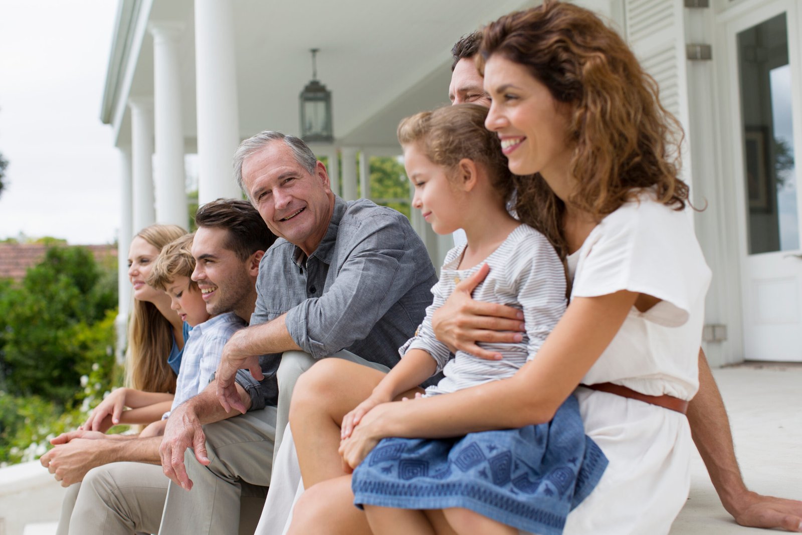 Life Settlement Tax - Inheritance Tax - Grandfather sitting on the patio witht his family. Mulit-generation.