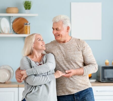 Life Settlement Brokers - happy mature couple dancing in kitchen