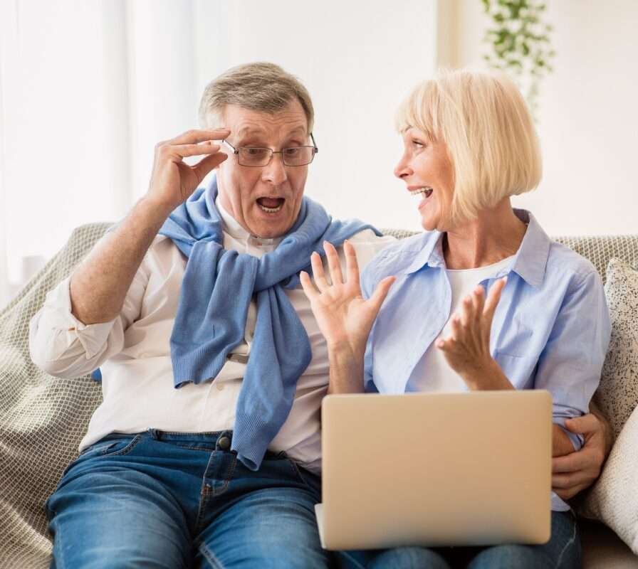 Life Settlement - a man and woman sitting on a couch with a laptop