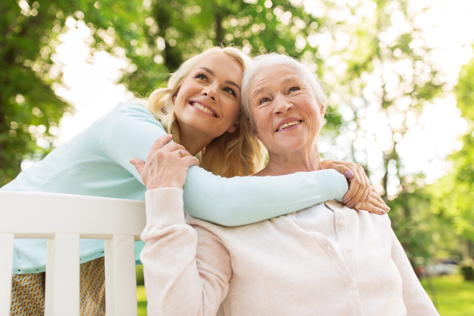 Get Cash From Life Insurance - daughter with senior mother hugging on park bench