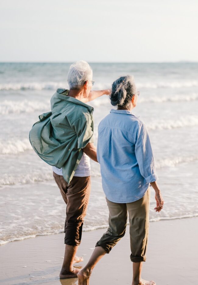 Your Life Insurance Contract: Elderly couple walking on the beach at sunset