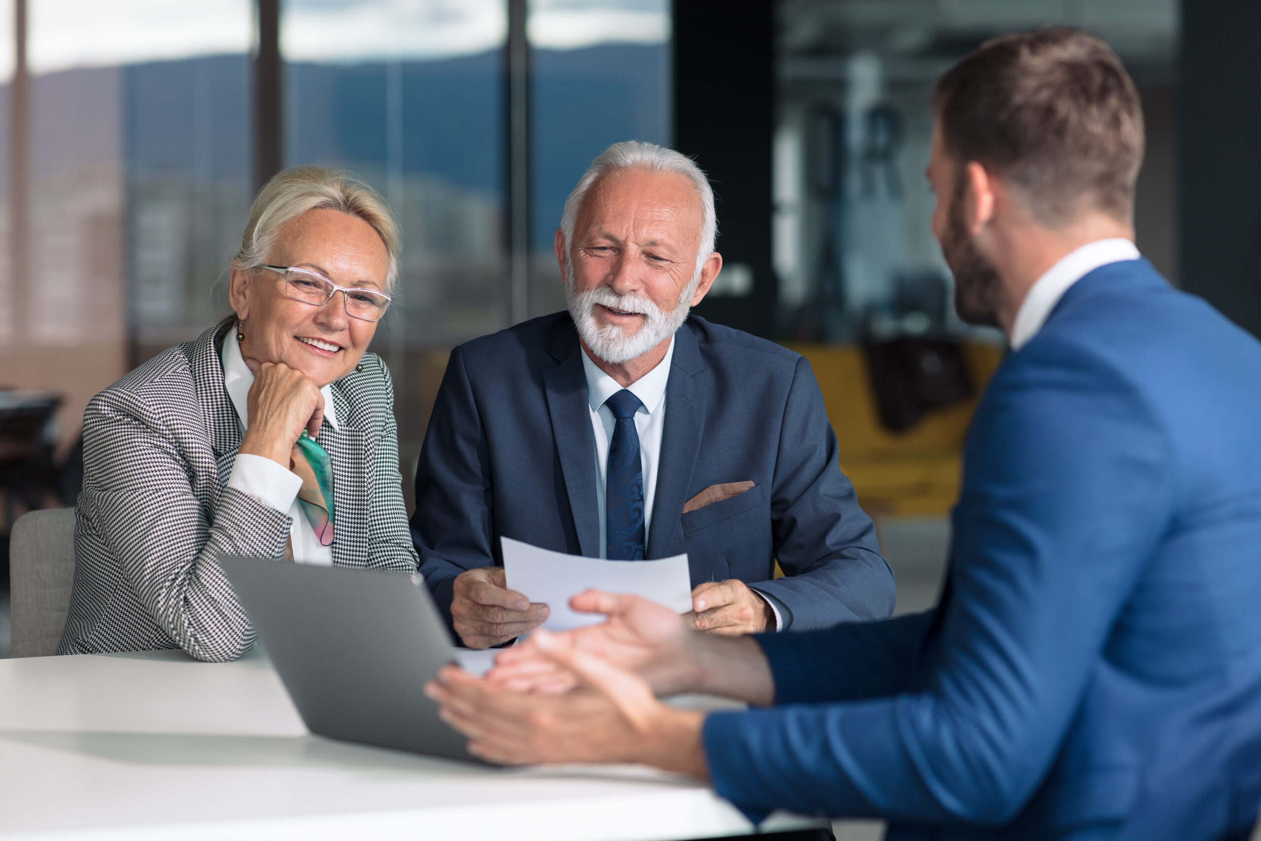 Buy-Sell Agreements - happy senior couple consulting with insurance agent