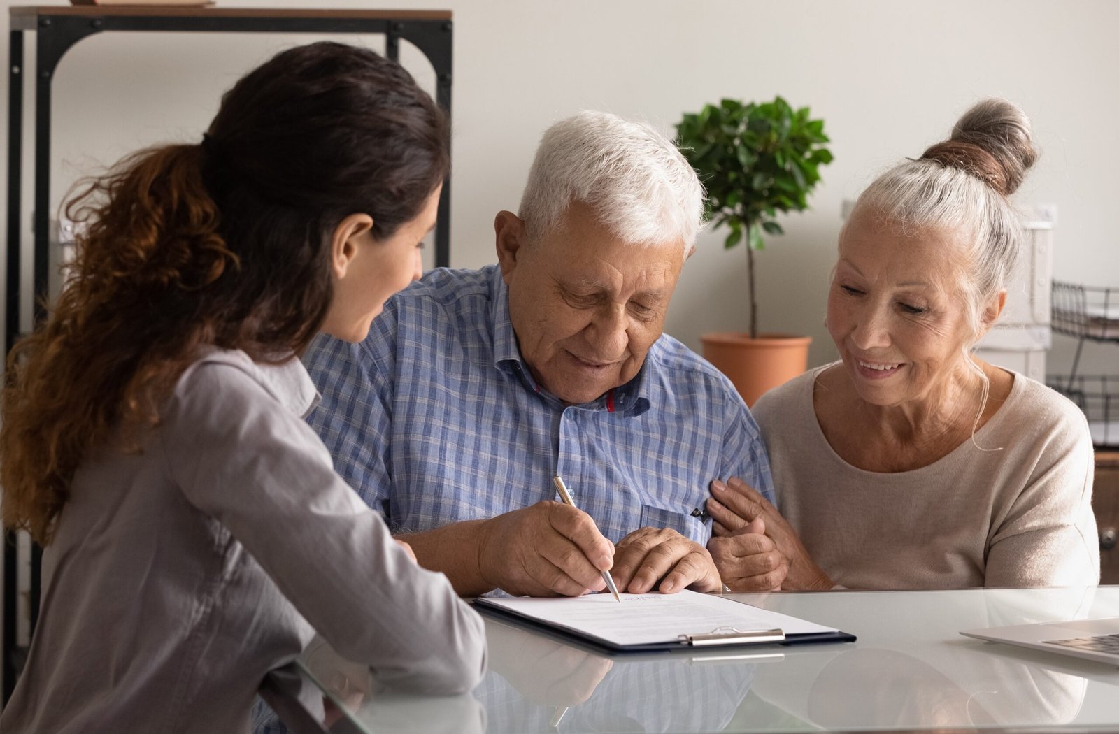 Sell Life Insurance Policy - Happy elderly couple close deal with specialist in office
