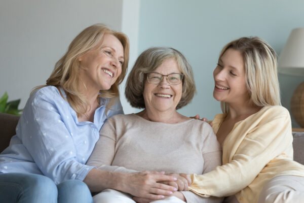 Cash Out a Life Insurance Policy: Cheerful caring adult granddaughter and middle aged mom hugging grandmother
