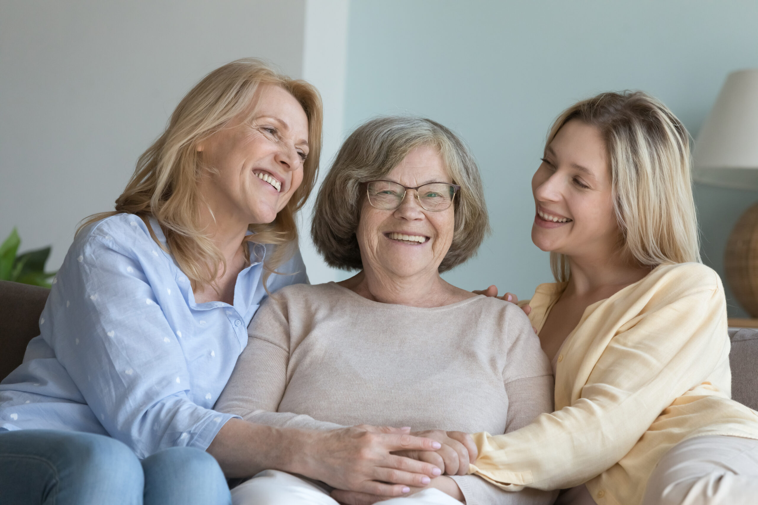 Cash Out a Life Insurance Policy: Cheerful caring adult granddaughter and middle aged mom hugging grandmother