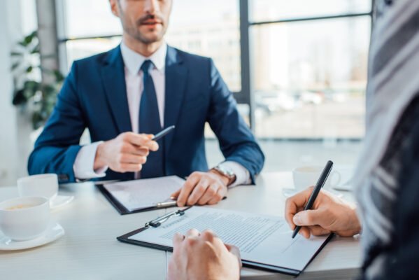 Who Buys Life Insurance Policies? - Businessmen signing contract in meeting