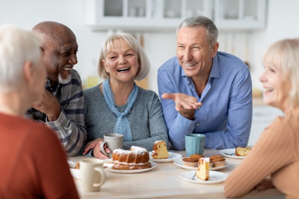How Much Is My Life Insurance Policy Worth? 2025 Life Settlement Guide: Group of happy senior people drinking tea with cake