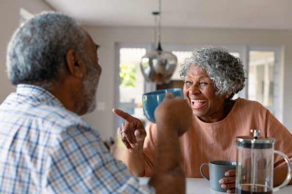 Broker Life Settlement: How to Maximize Your Cash Payout 1 broker life settlement: Happy senior couple sitting in kitchen with coffee and talking