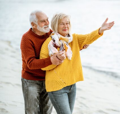 Who Buys Life Insurance Policies: Senior couple in sweaters on the seashore