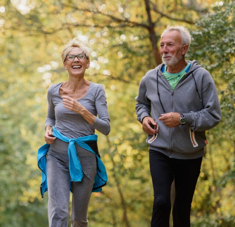 Sell life insurance- active senior couple jogging in the park. Exercise together to stop aging.
