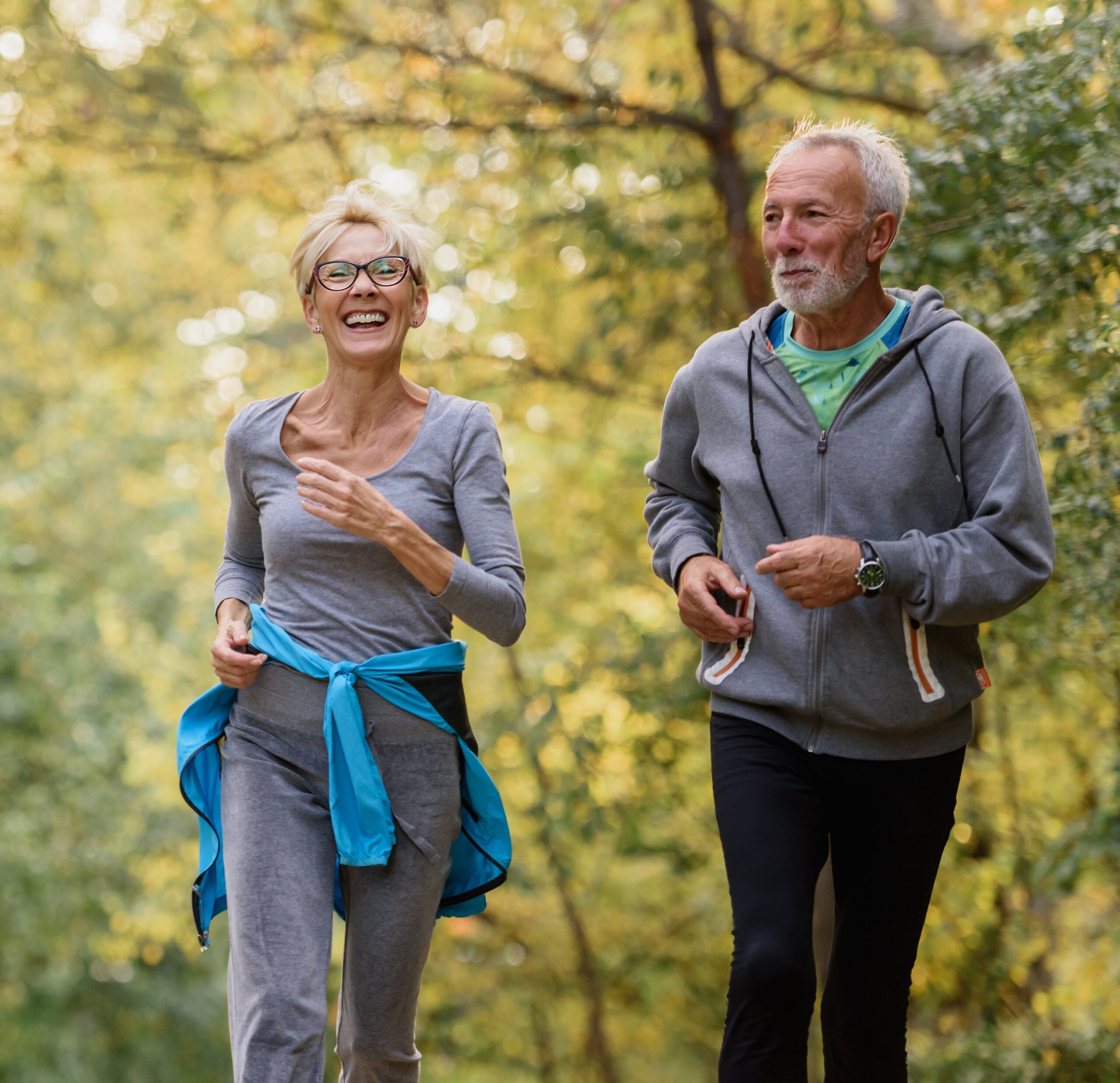 Sell life insurance- active senior couple jogging in the park. Exercise together to stop aging.