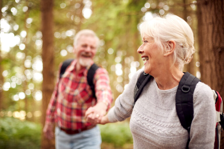How to sell a term life insurance policy: Loving Retired Senior Couple Holding Hands Hiking In Woodland Countryside Together