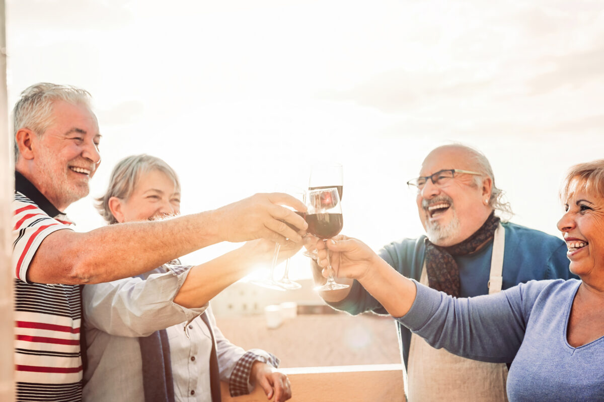 surrender life insurance policy - Happy seniors friends drinking red wine on terrace sunset - Pensioners people having fun enjoying time together outdoor - Elderly retirement lifestyle concept